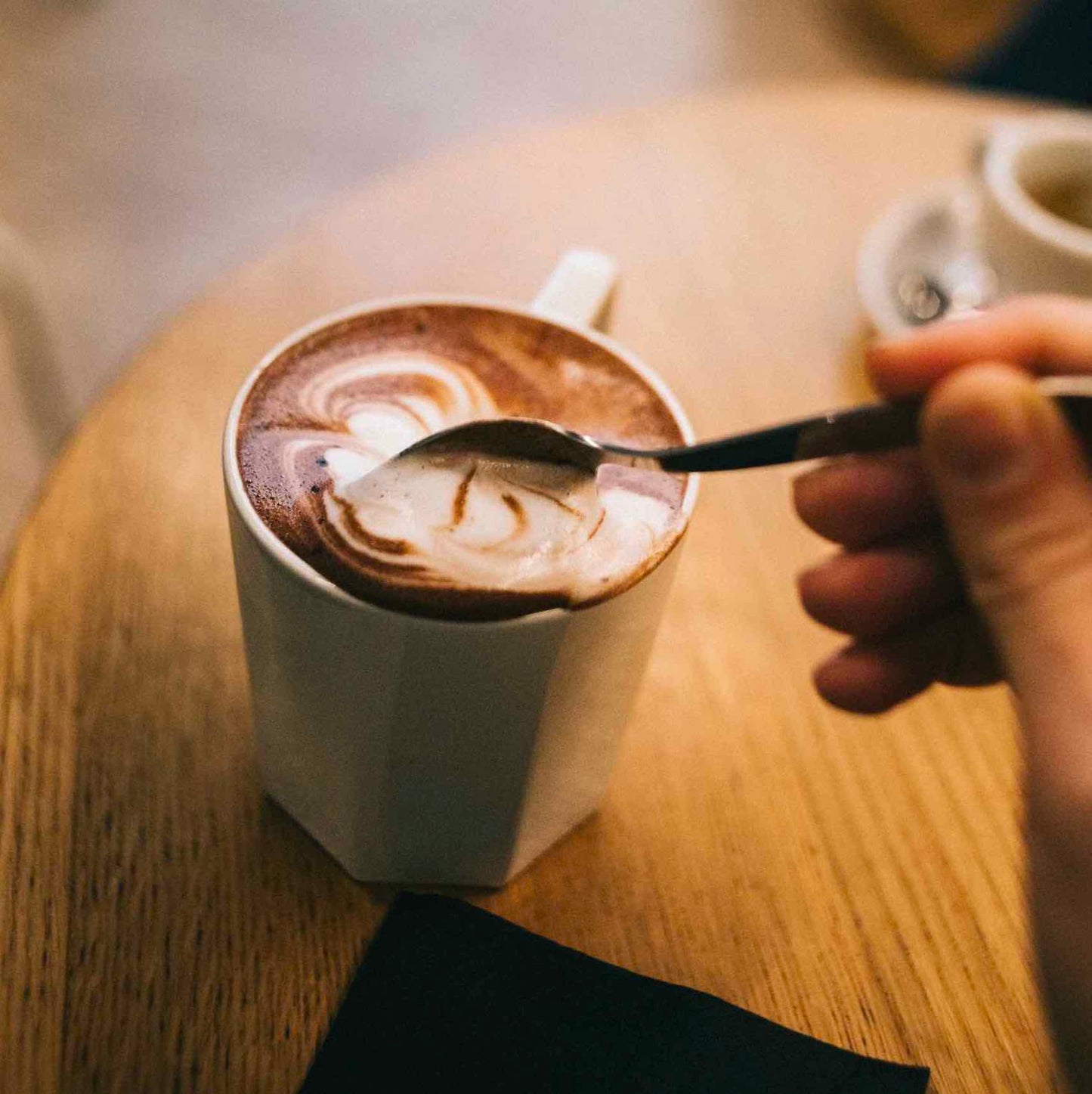 zoom sur une tasse remplie de chocolat chaud by awachai dans un coffee shop