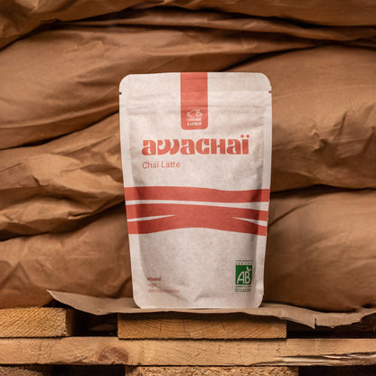 paquet de chai latte 1kg awachai présenté sur une palette devant des sacs de marchandises 