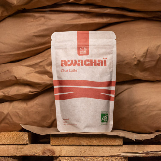 paquet de chai latte 1kg awachai présenté sur une palette devant des sacs de marchandises 