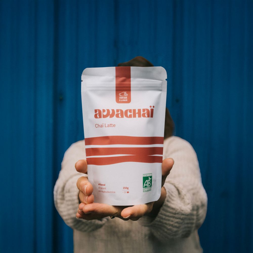 Image représentant le paquet du chai latte 250gr de chez awachai présenté posé sur des mains 