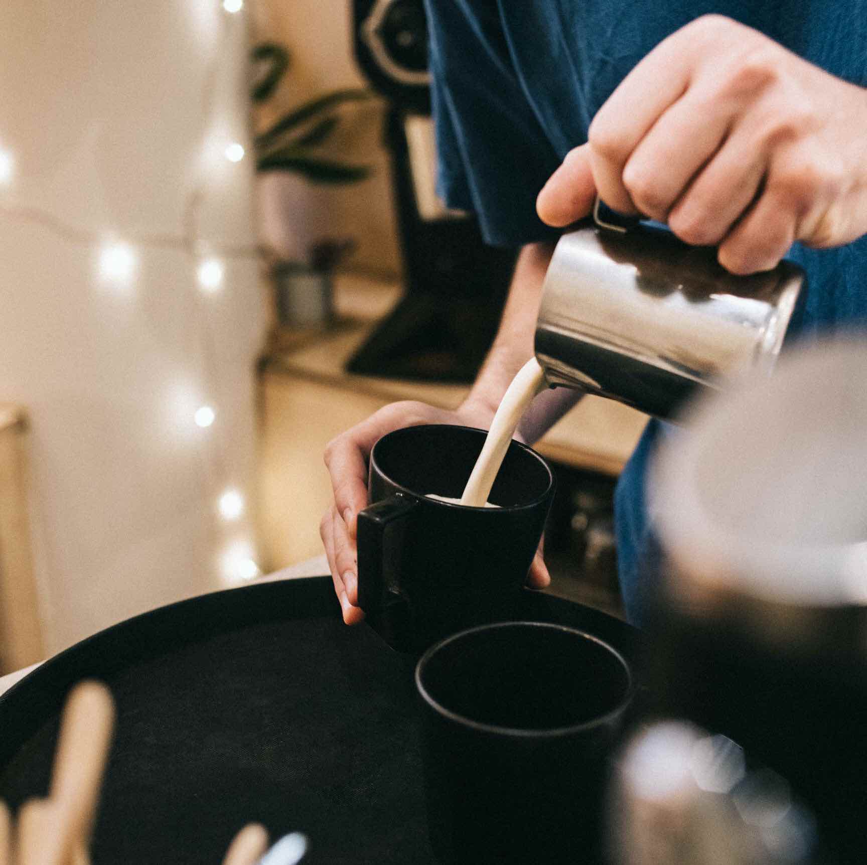 photo montrant un chai latte masala de chez awachai en préparation. on voit ici le barista qui verse le lait. 