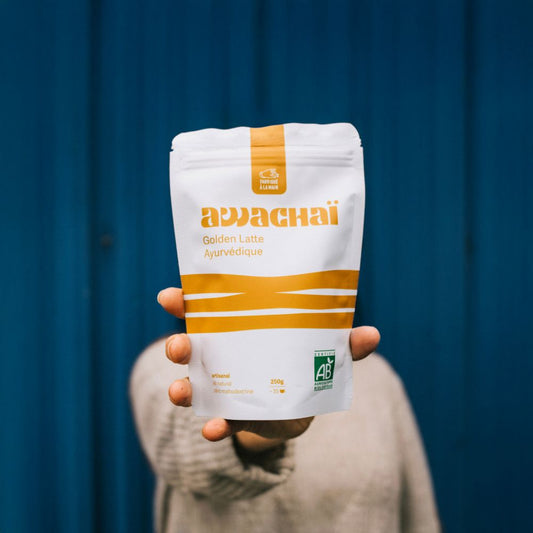 la photo montre un paquet du golden latte en poudre awachai format 250gr tenu dans une main
