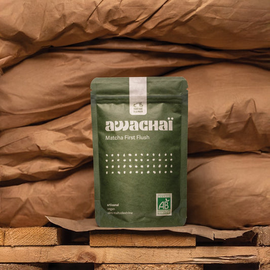 Matcha first flush de chez awachai présenté dans son paquet et posé devant des sacs de marchandises 